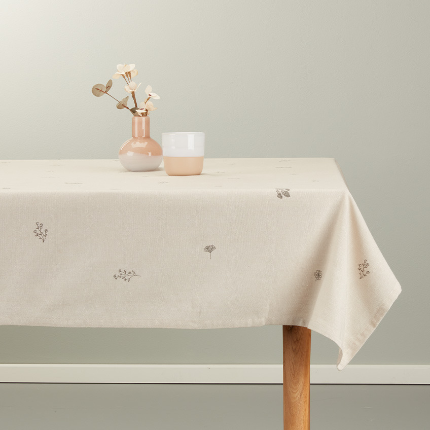 Tischdecke auf einem Esstisch in warmem Beige mit Becher und Vase in weiß-rosa