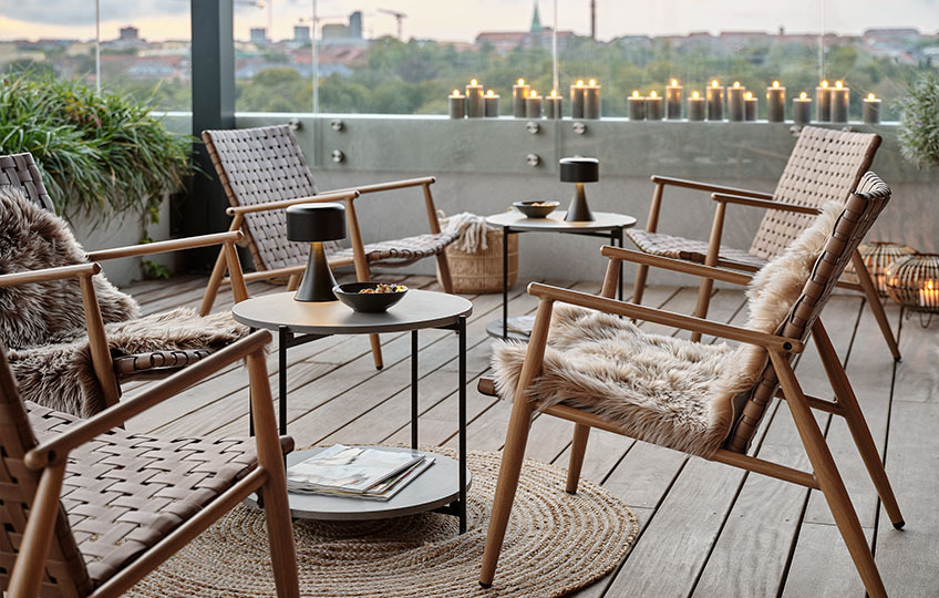 Garten-Beistelltisch mit Tischplatte aus Faserzement und Lounge-Stühle auf einer Terrasse